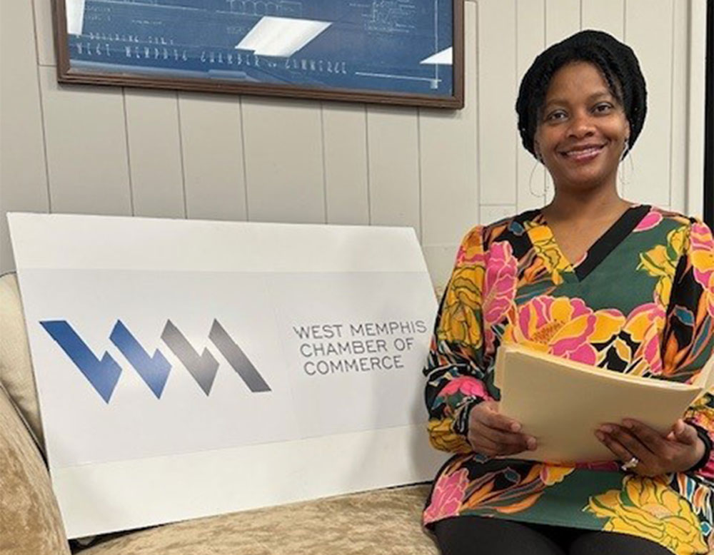 AV抖阴 professor Dr. Kimberly Wolfe poses with West Memphis Chamber of Commerce signage after being elected to board of directors.